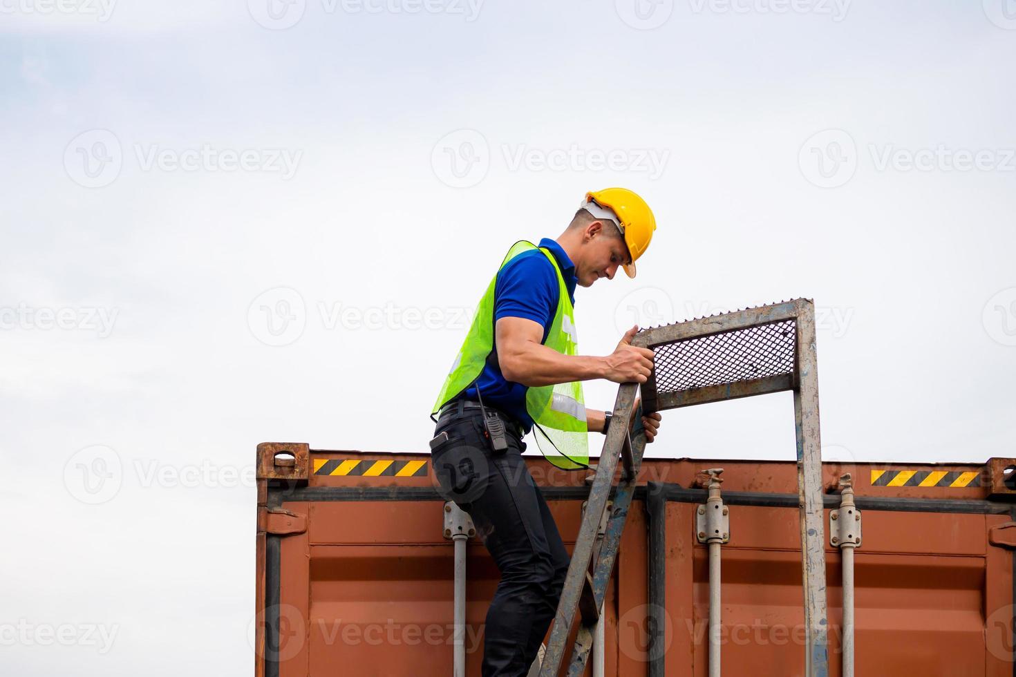 el trabajador de la fábrica sube la escalera hasta el contenedor foto