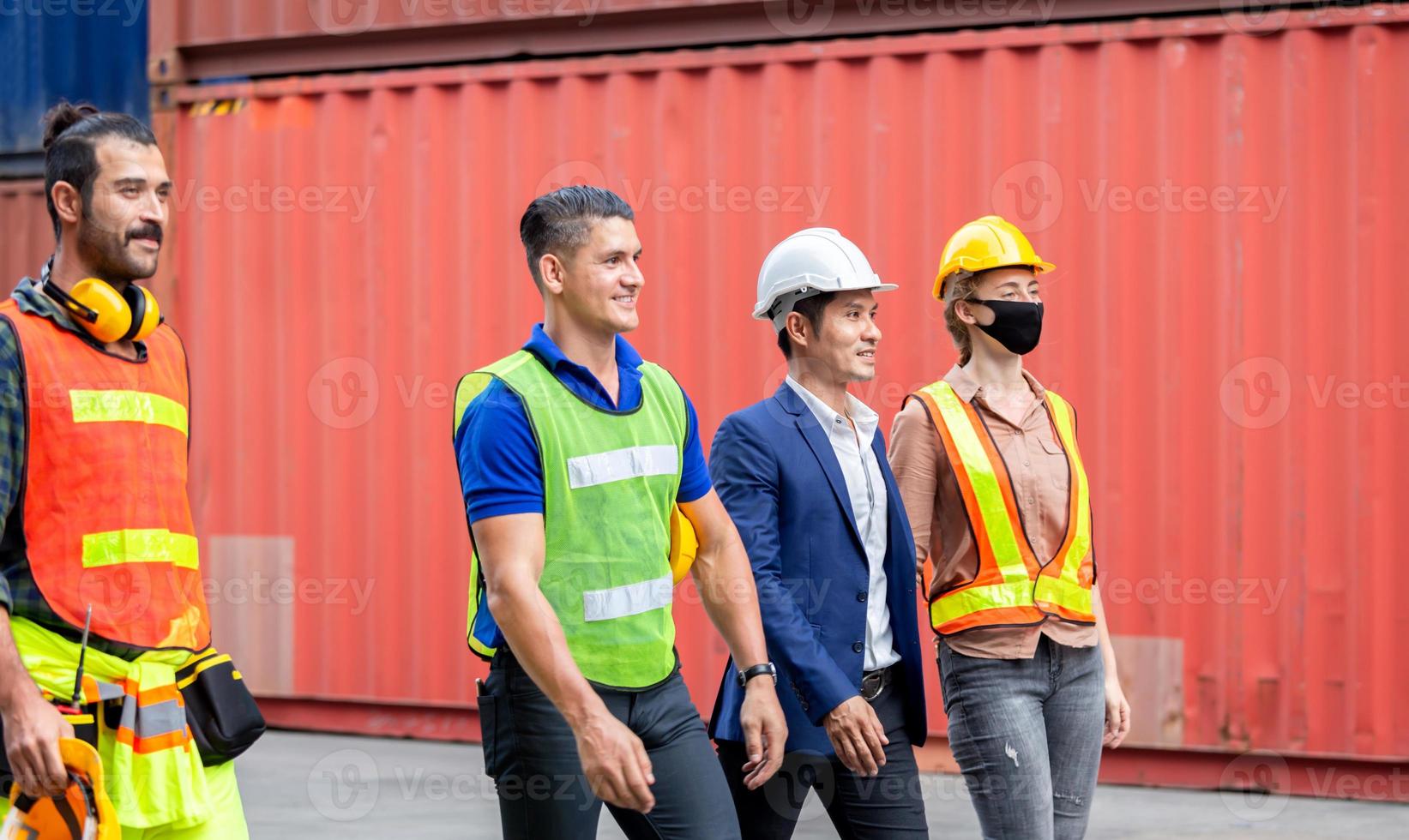 equipo de ingenieros y trabajadores caminando en el contenedor de carga foto