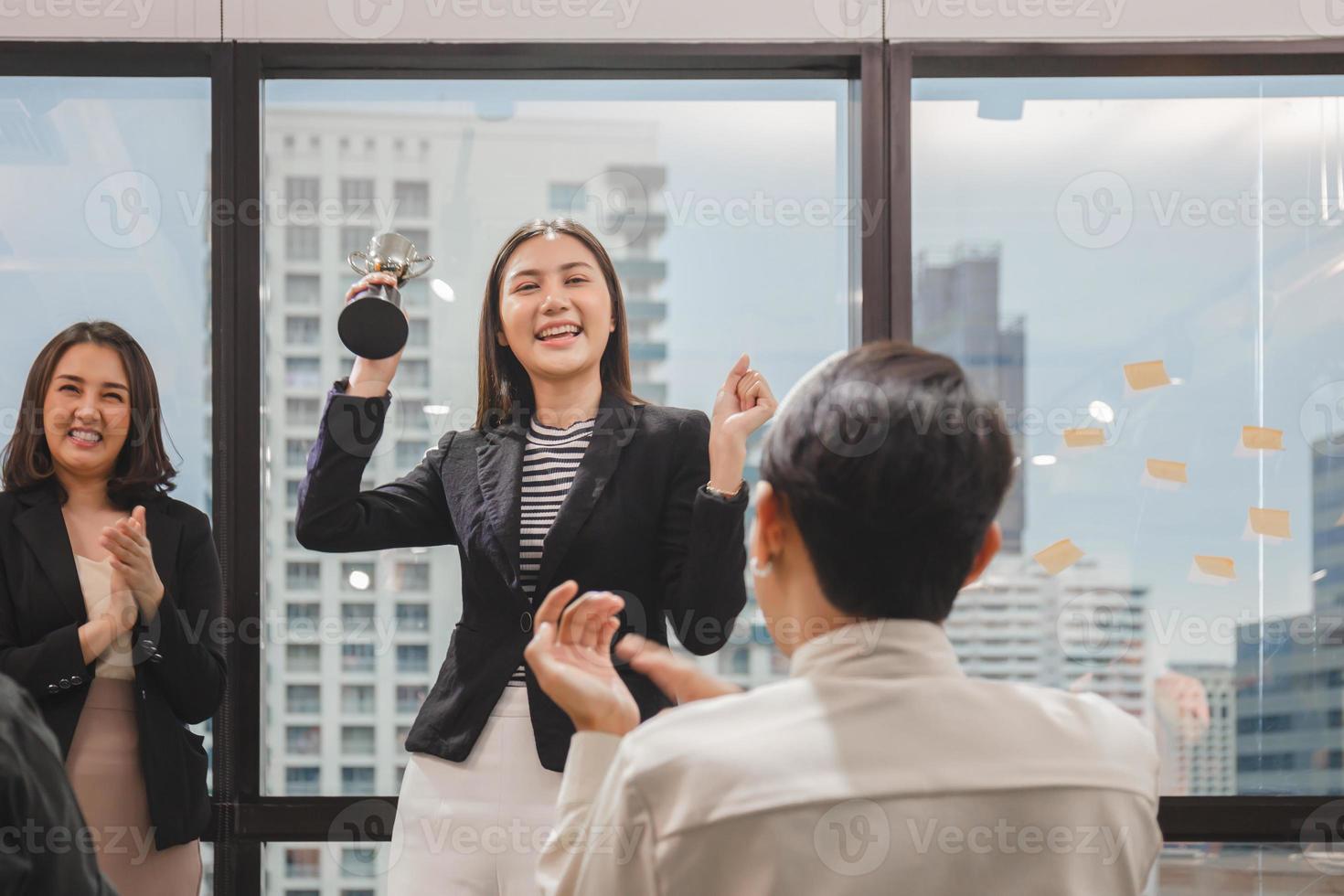 mujer de negocios con trofeo de premio muestra la victoria en la sala de reuniones, conceptos de equipo de felicidad de éxito de celebración foto