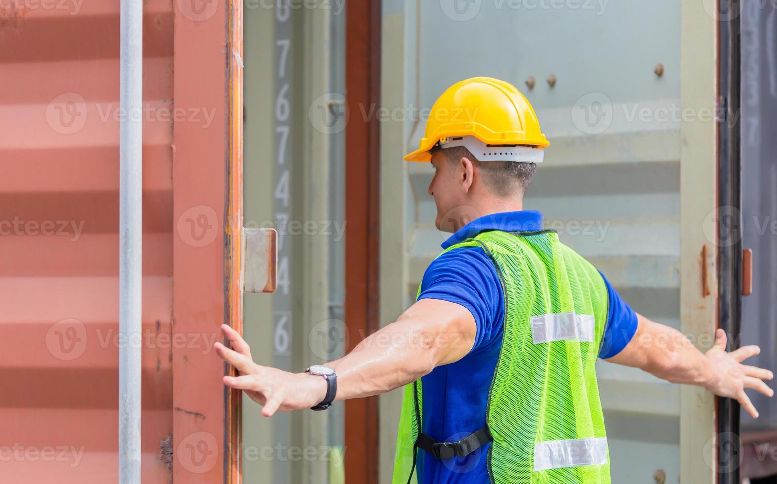 Engineer worker man in hardhat and safety vest checking containers box from cargo photo