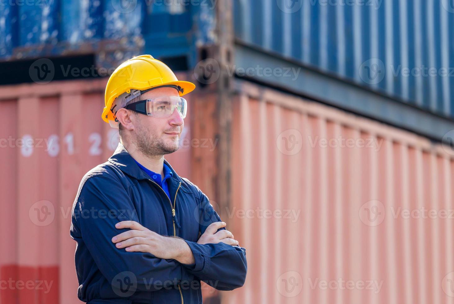 Cheerful factory worker man in hard hat smiling with arms crossed as sign of Success photo
