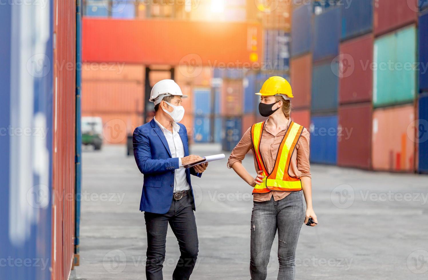 Engineer wearing protection face mask against coronavirus, Foreman worker team checking containers box from cargo photo