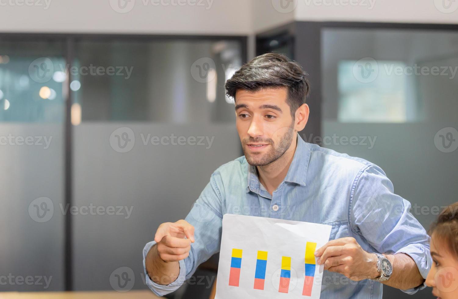 Young business team of coworkers meeting in creative office, businessman holding paper and sitting on table, Teamwork concept photo