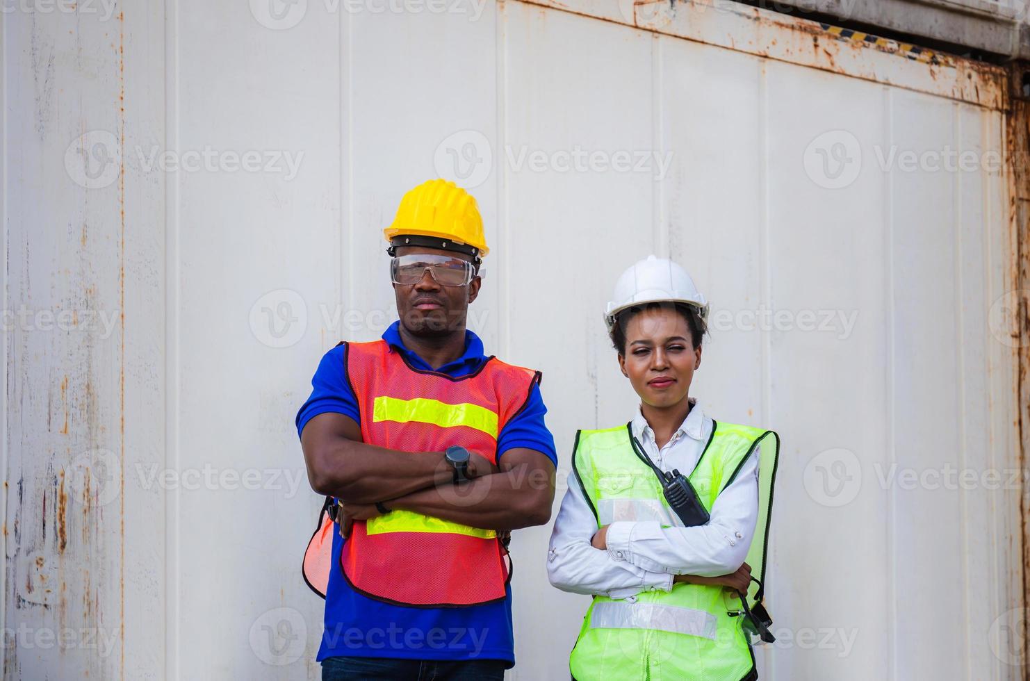 Cheerful factory worker team smiling with arms crossed at cargo containers photo