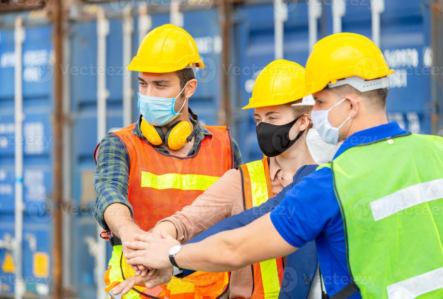 equipo de ingenieros y trabajadores de fábrica uniéndose a la carga de contenedores, concepto de trabajo en equipo de éxito foto