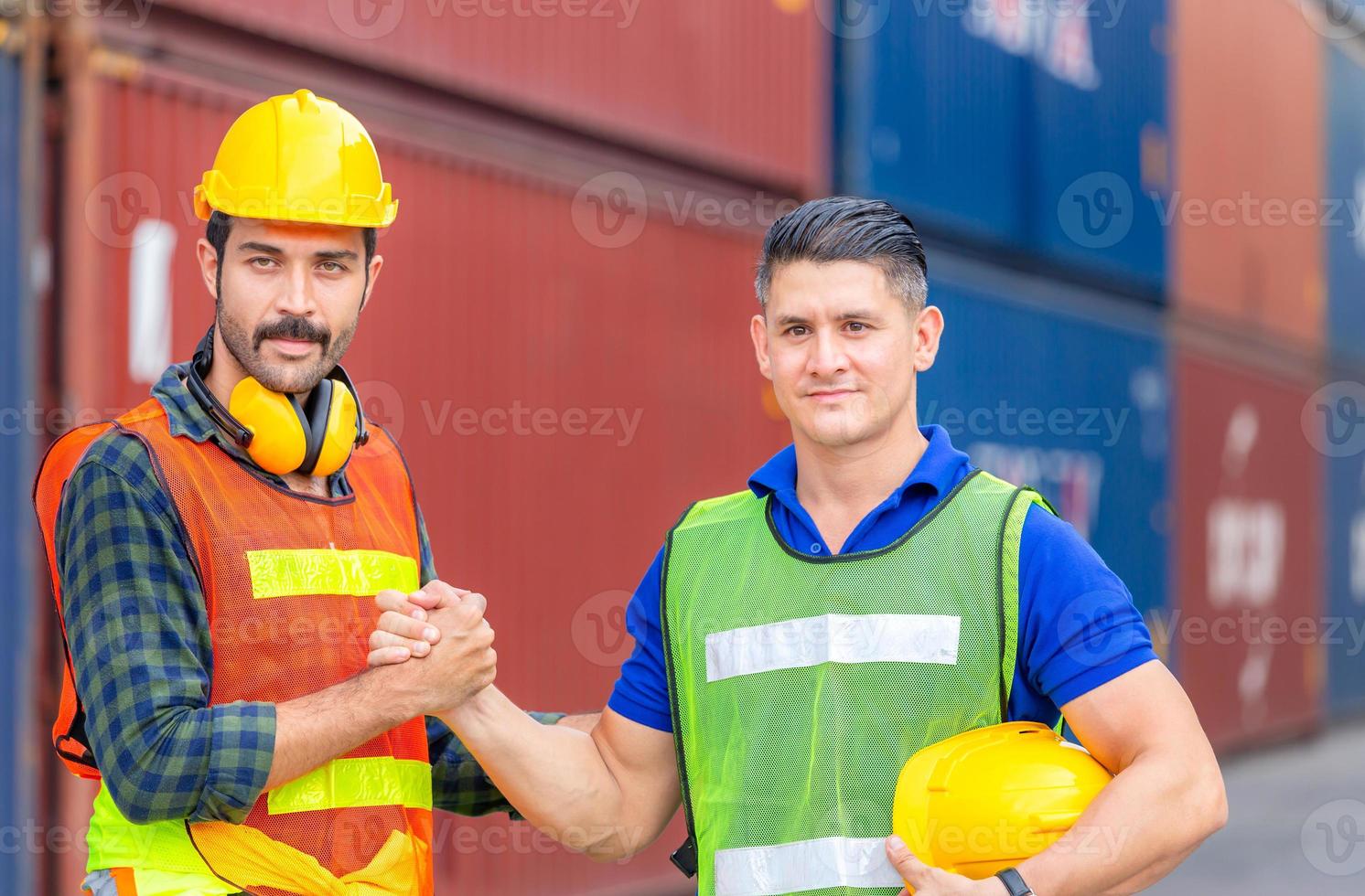 apretón de manos de ingeniero y hermano del alma del trabajador, apretón de manos con cierre de pulgar o apretón de manos homie con fondo de carga de contenedores borrosos, concepto de éxito y trabajo en equipo foto