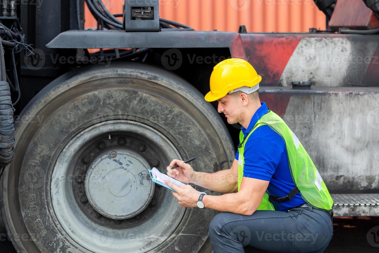 rueda de control mecánico en contenedor de carga. técnico profesional precomprobación de neumáticos de carretillas elevadoras, concepto de seguridad. foto