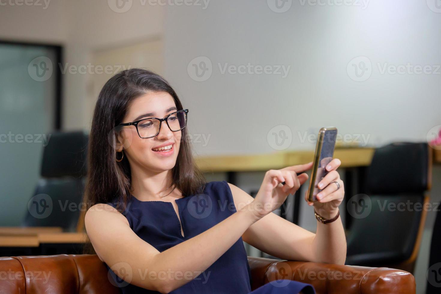 alegre mujer casual tomando selfie relajándose en la oficina moderna foto