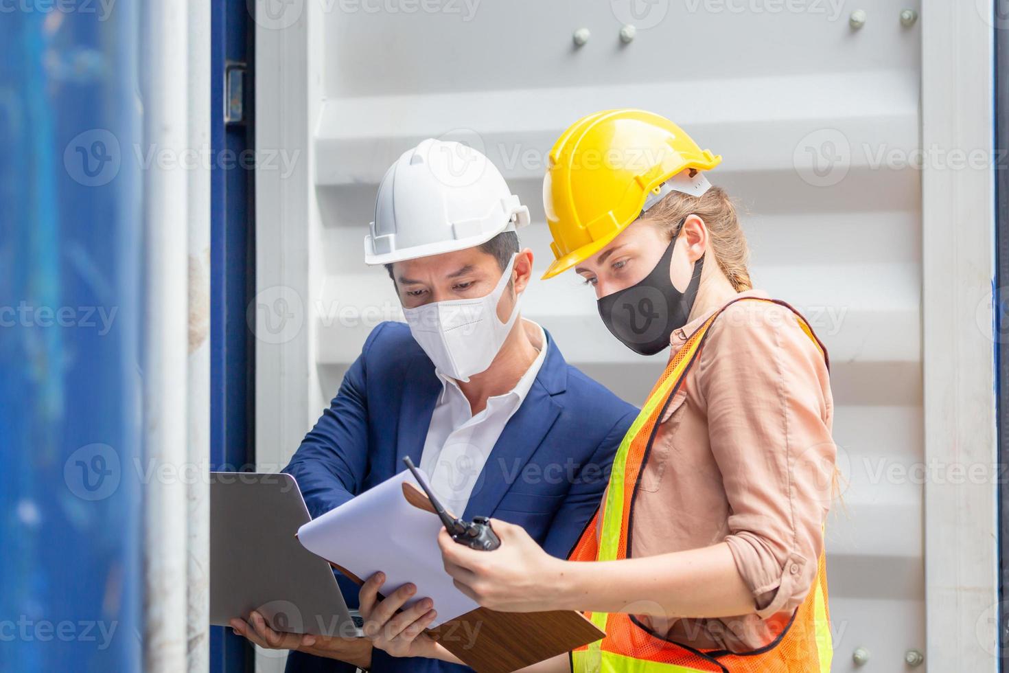 Engineer wearing protection face mask against coronavirus, Foreman worker team checking containers box from cargo photo