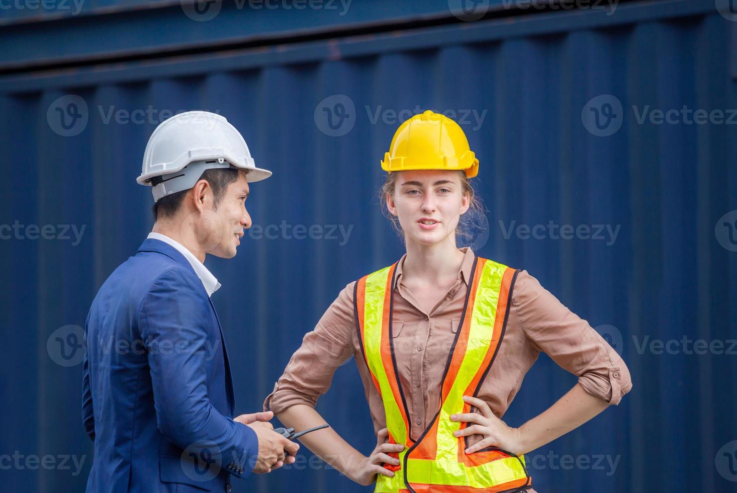 Cheerful engineer and worker team checking containers box, foreman in hardhat and safety vest at cargo photo
