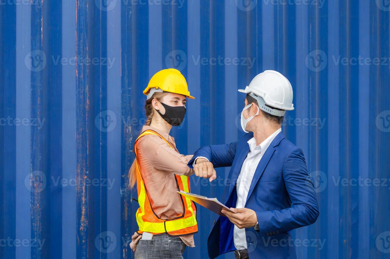 Engineer and worker wearing protection face mask against coronavirus and shaking elbows, New novel greeting to avoid the spread of coronavirus photo