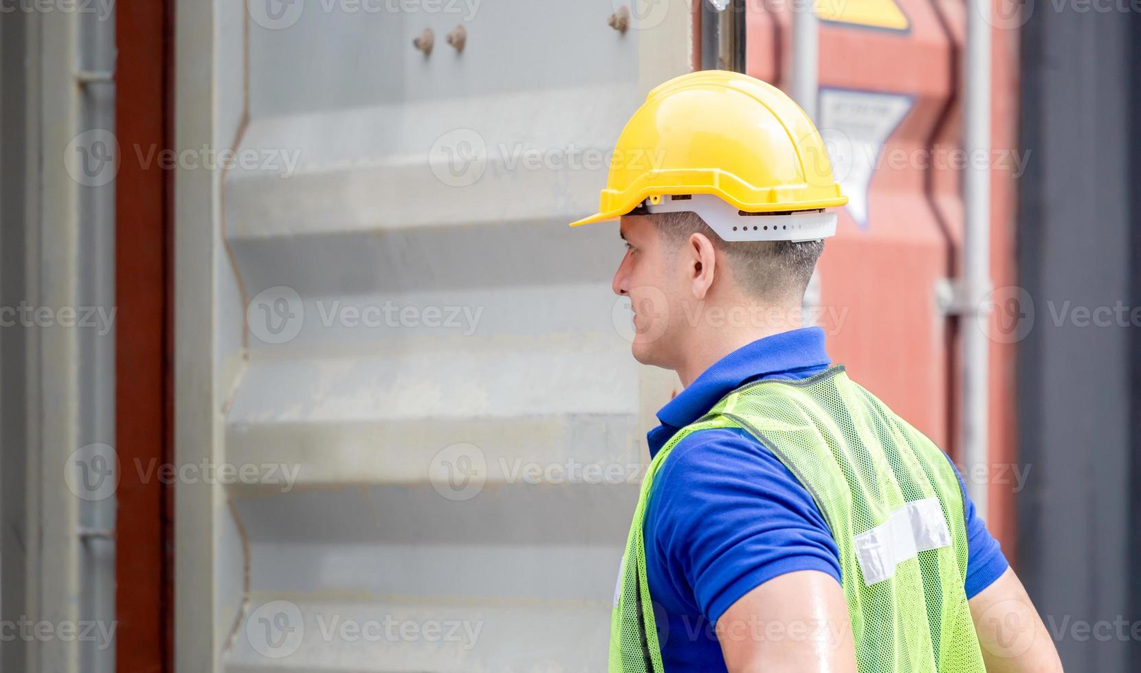Engineer worker man in hardhat and safety vest checking containers box from cargo photo