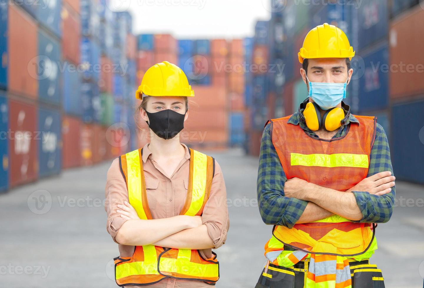 Success Teamwork Concept, Business people engineer and worker team wearing protection face mask against coronavirus with arms crossed as sign of success blurred container box background photo