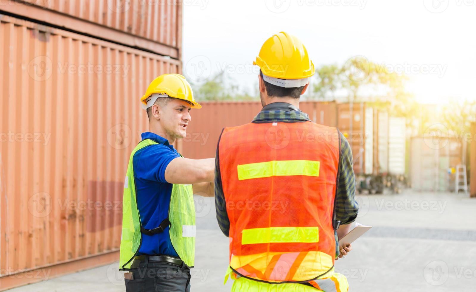 Engineer and foreman worker team checking containers box from cargo with blurred background, Teamwork concept photo
