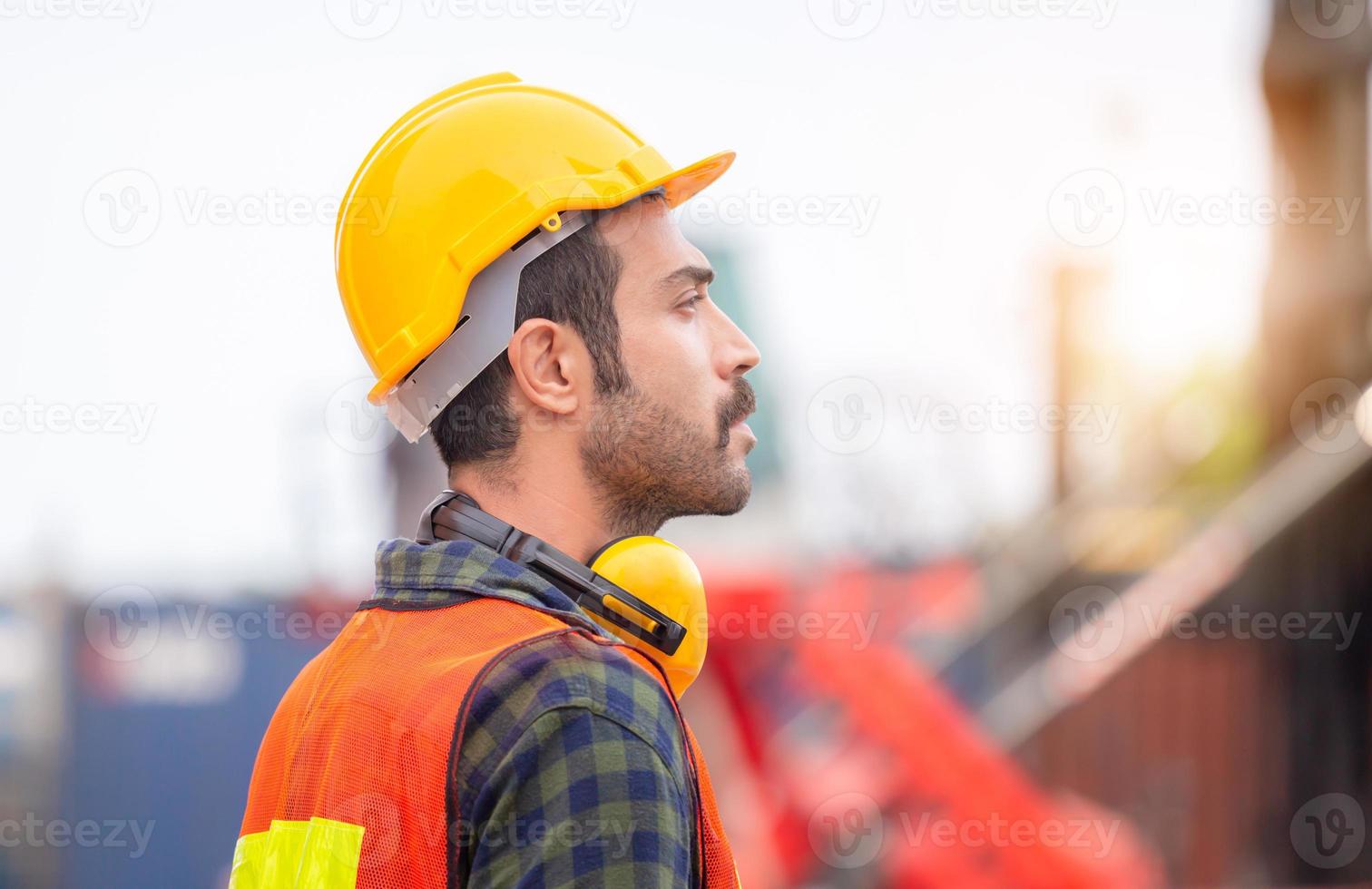 Engineer man in hardhat and safety vest control loading containers box from cargo, Logistic concept photo