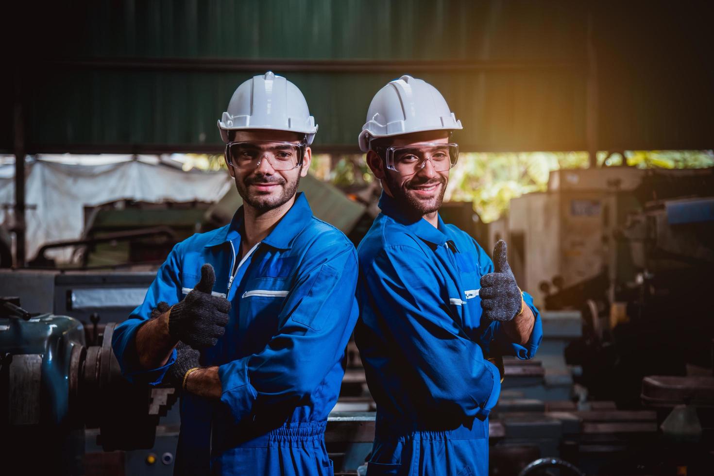 ingeniería industrial con control uniforme de seguridad que opera la máquina rectificadora de torno que trabaja en la fábrica de la industria. foto