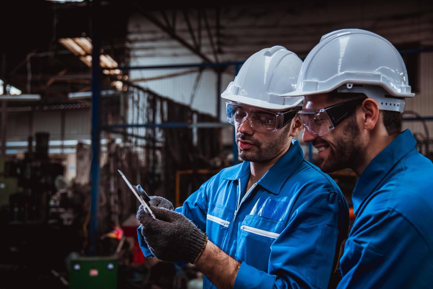 ingeniería industrial con control uniforme de seguridad que opera la máquina rectificadora de torno que trabaja en la fábrica de la industria. foto