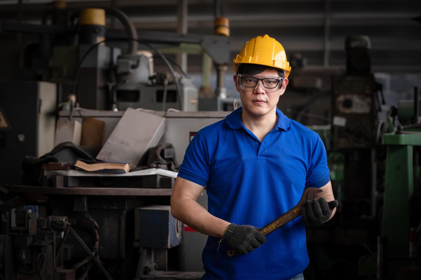 ingeniería industrial con control uniforme de seguridad que opera la máquina rectificadora de torno controlada por computadora que trabaja en la fábrica de la industria. foto