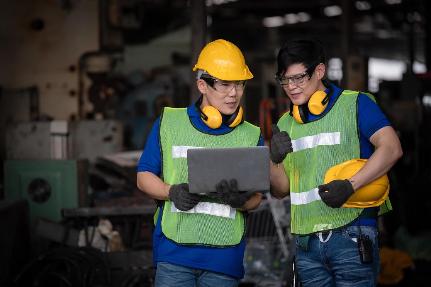 Industry engineering wearing safety uniform control operating computer controlled lathe grinding machine working in industry factory. photo