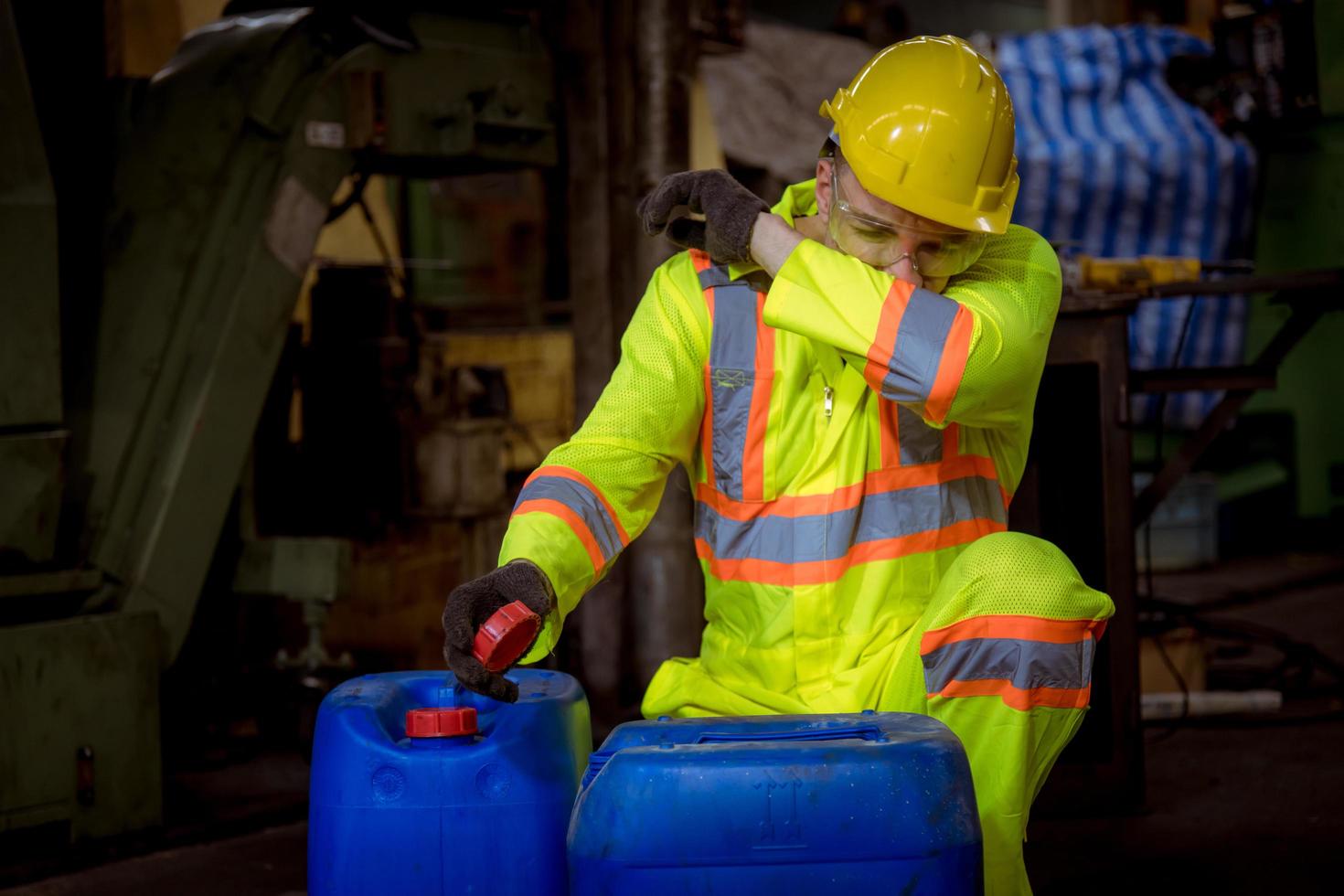 Engineer industry wearing safety uniform ,black gloves ,gas mask feel suffocate when under checking chemical tank in industry factory work. photo