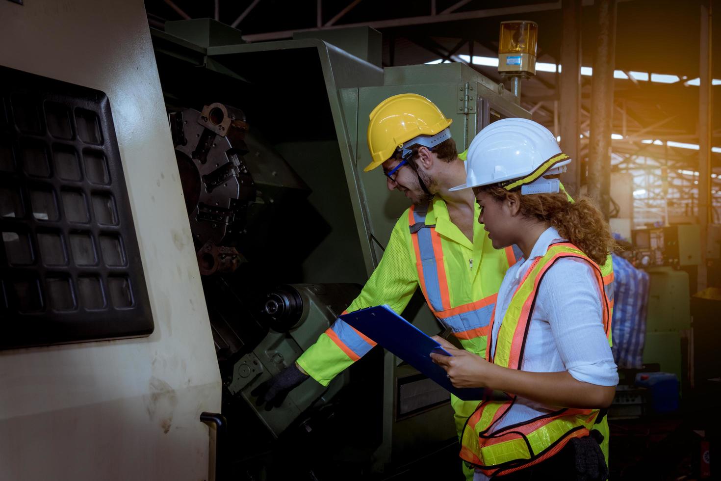 Industry engineering wearing safety uniform control operating computer controlled lathe grinding machine working in industry factory. photo