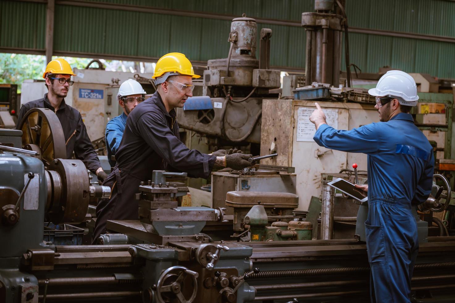 Industry engineering wearing safety uniform control operating computer controlled lathe grinding machine working in industry factory. photo