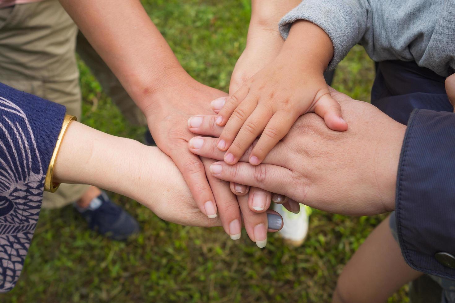 Top view of young people and kid putting their hands together photo