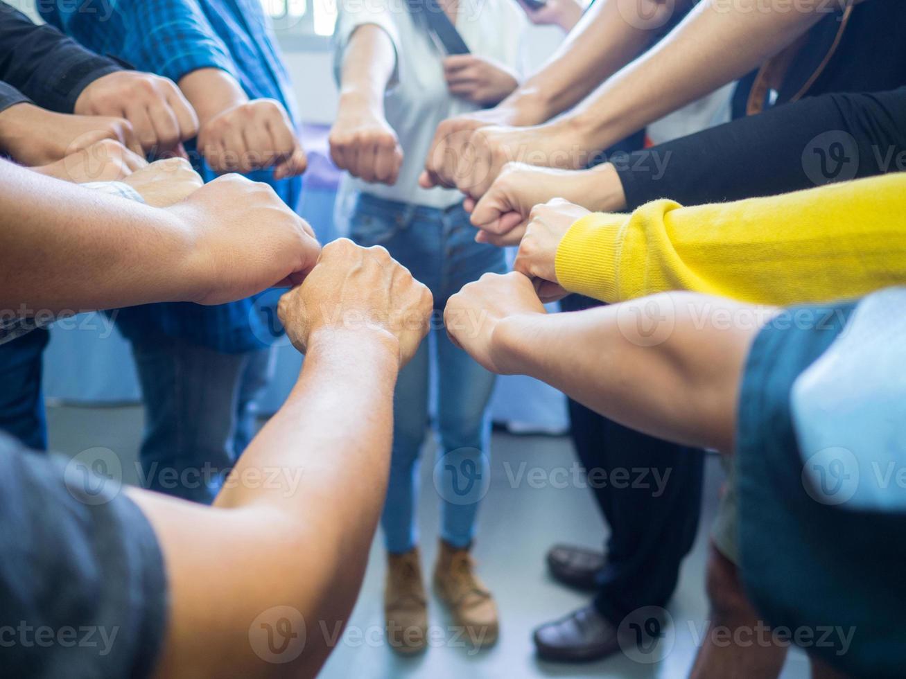 Close-up of many people hands show putting their fists together photo