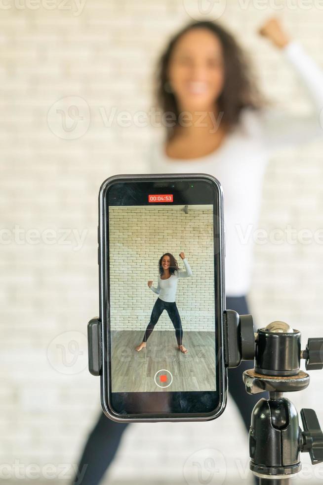 Latin woman created her dancing video by smartphone camera. To share video to social media application. photo
