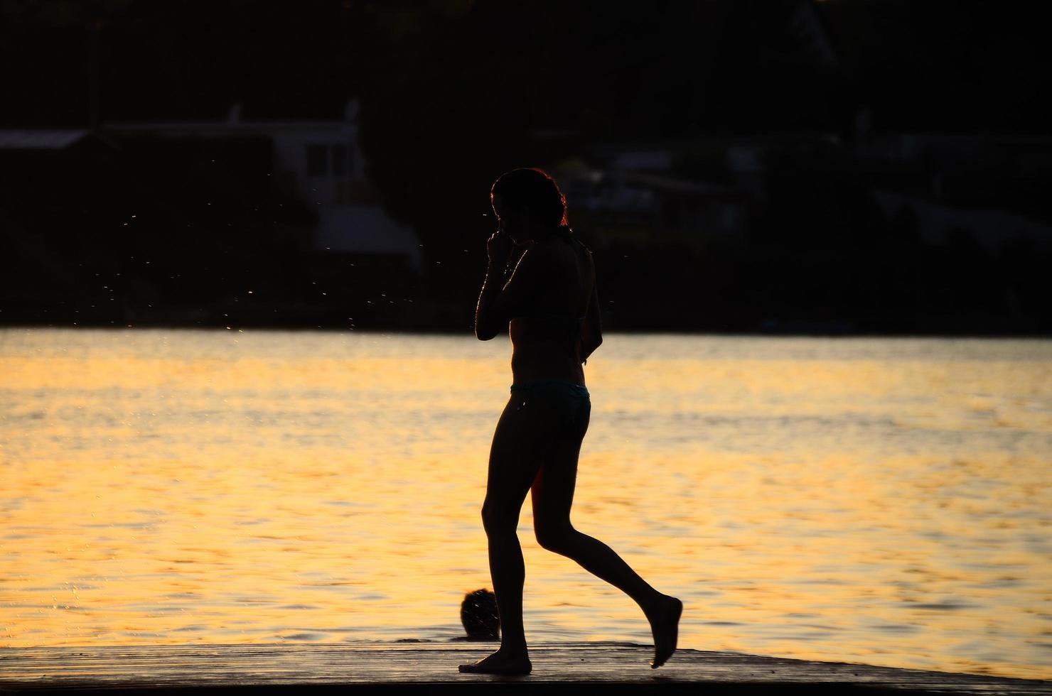 mujer en bikini caminando sobre el lago de la pasarela foto