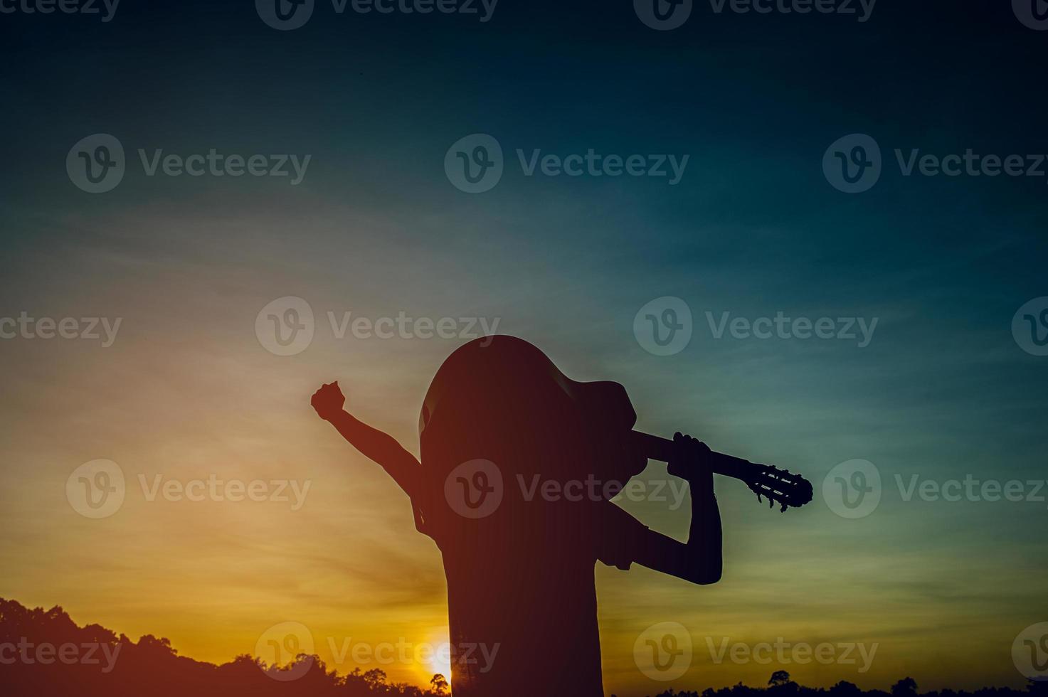 Silhouette of a guitarist in the shadows at sunset light, silhouette concept. photo