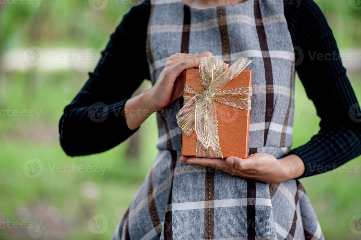 Hand and orange gift boxes give to your loved ones. Gift ideas photo