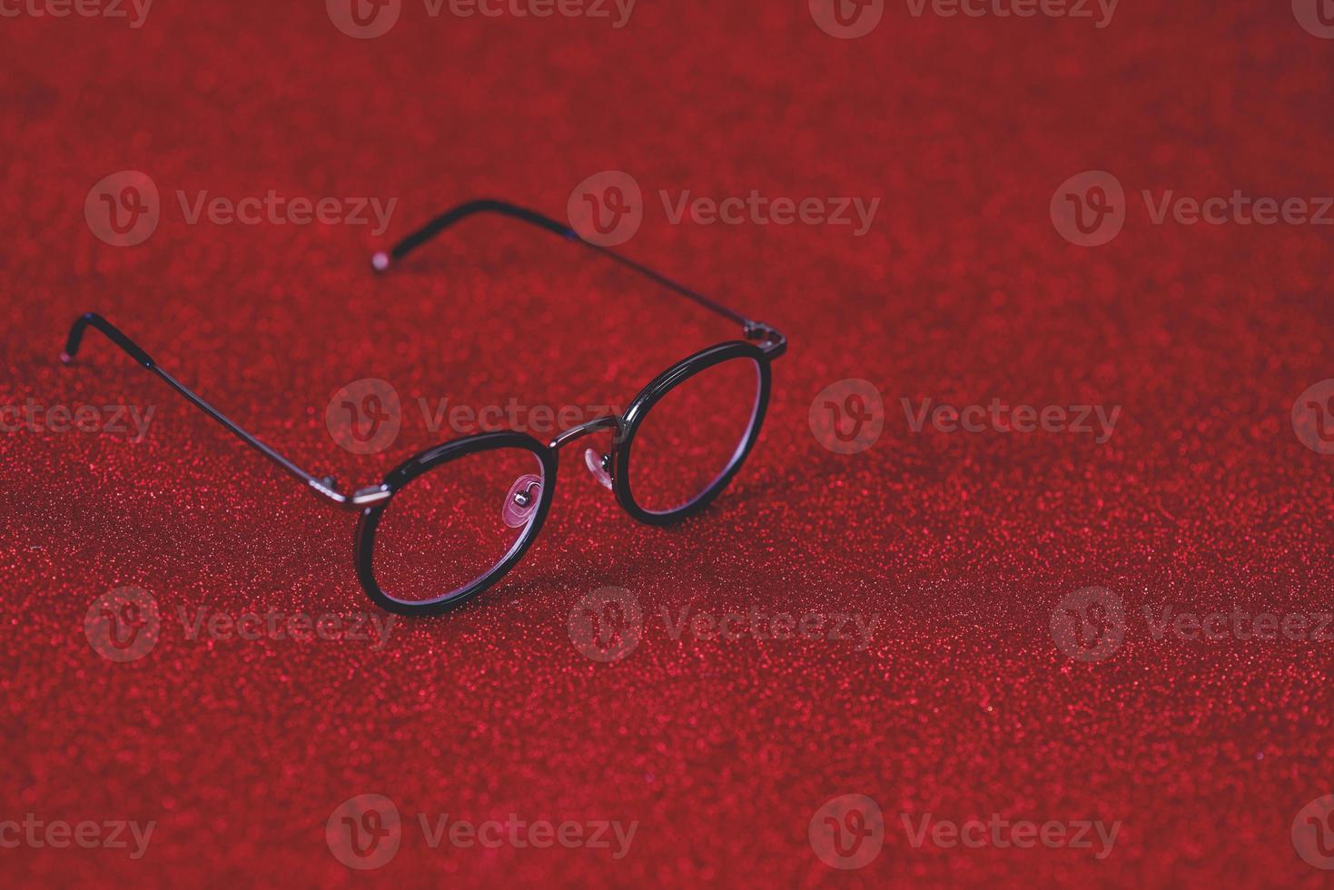 Red background image and black glasses. Visually concept. photo