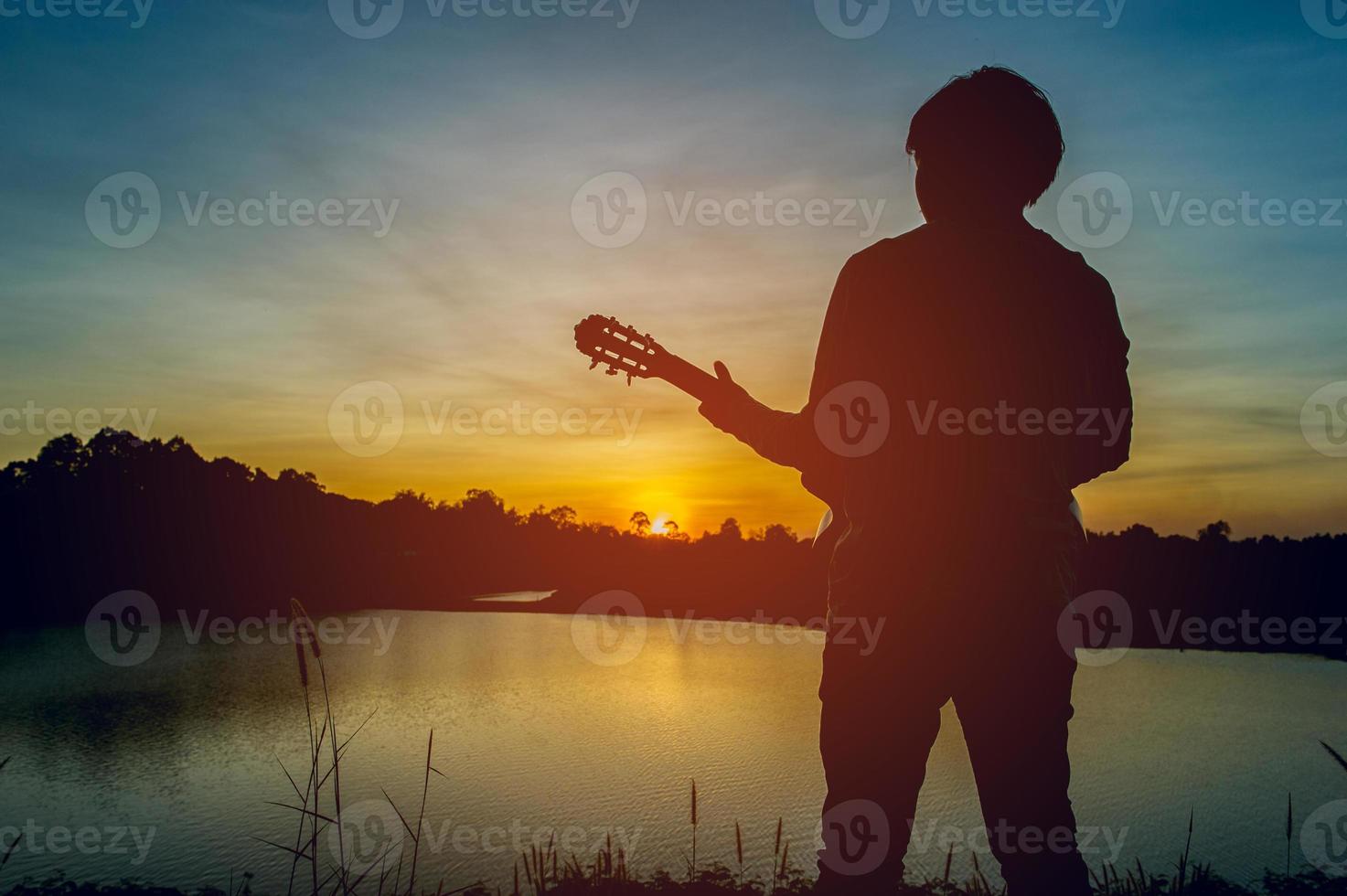 Silhouette of a guitarist in the shadows at sunset light, silhouette concept. photo