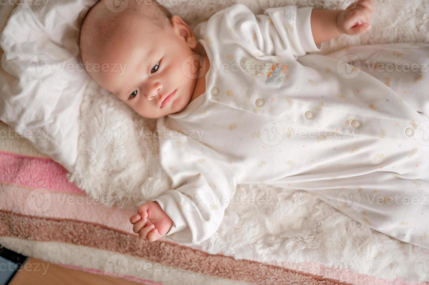 Cute baby boy in a white light bedroom Newborn baby is cute. In bedding for children born - images photo