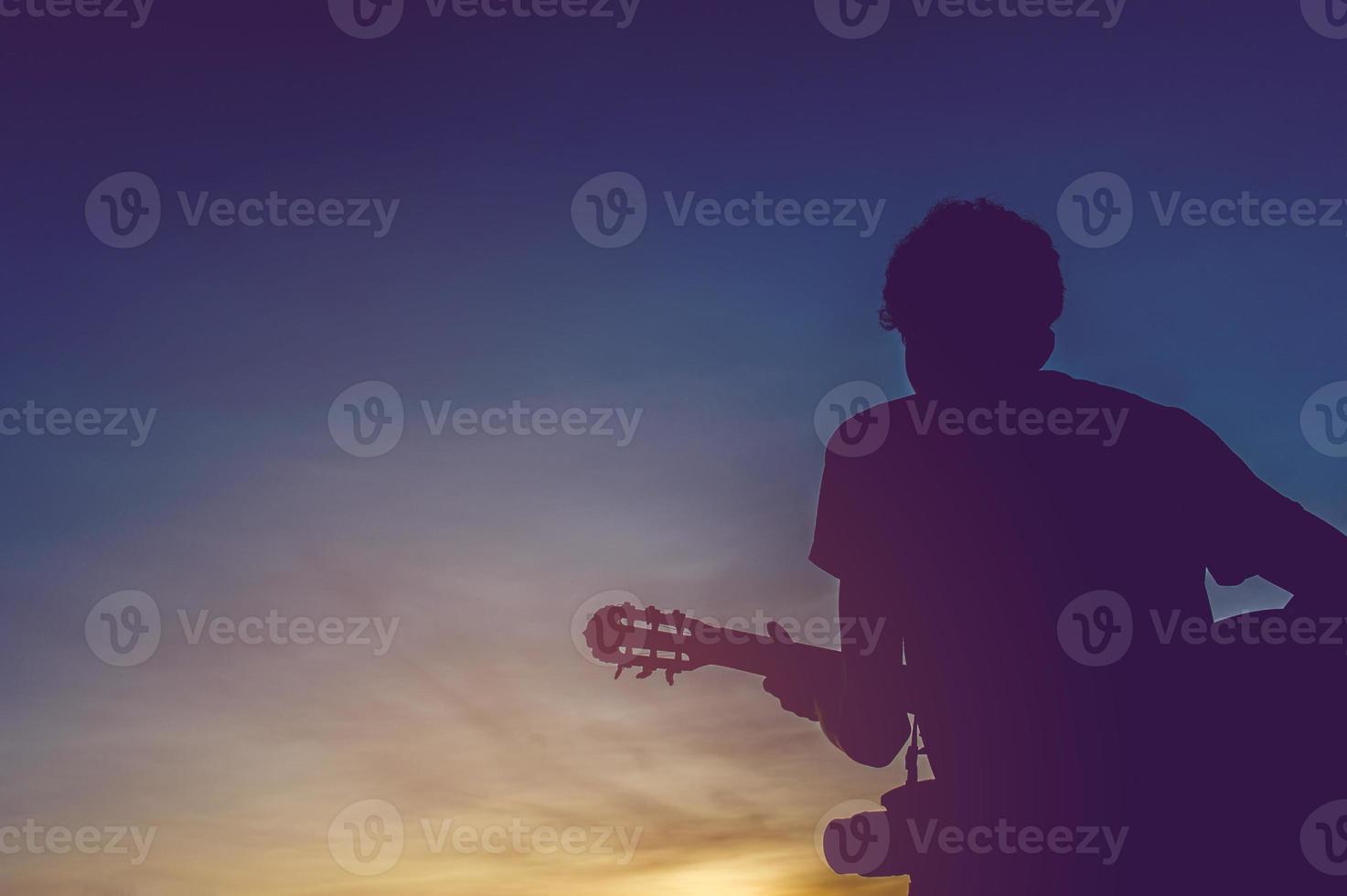 Silhouette of a guitarist in the shadows at sunset light, silhouette concept. photo