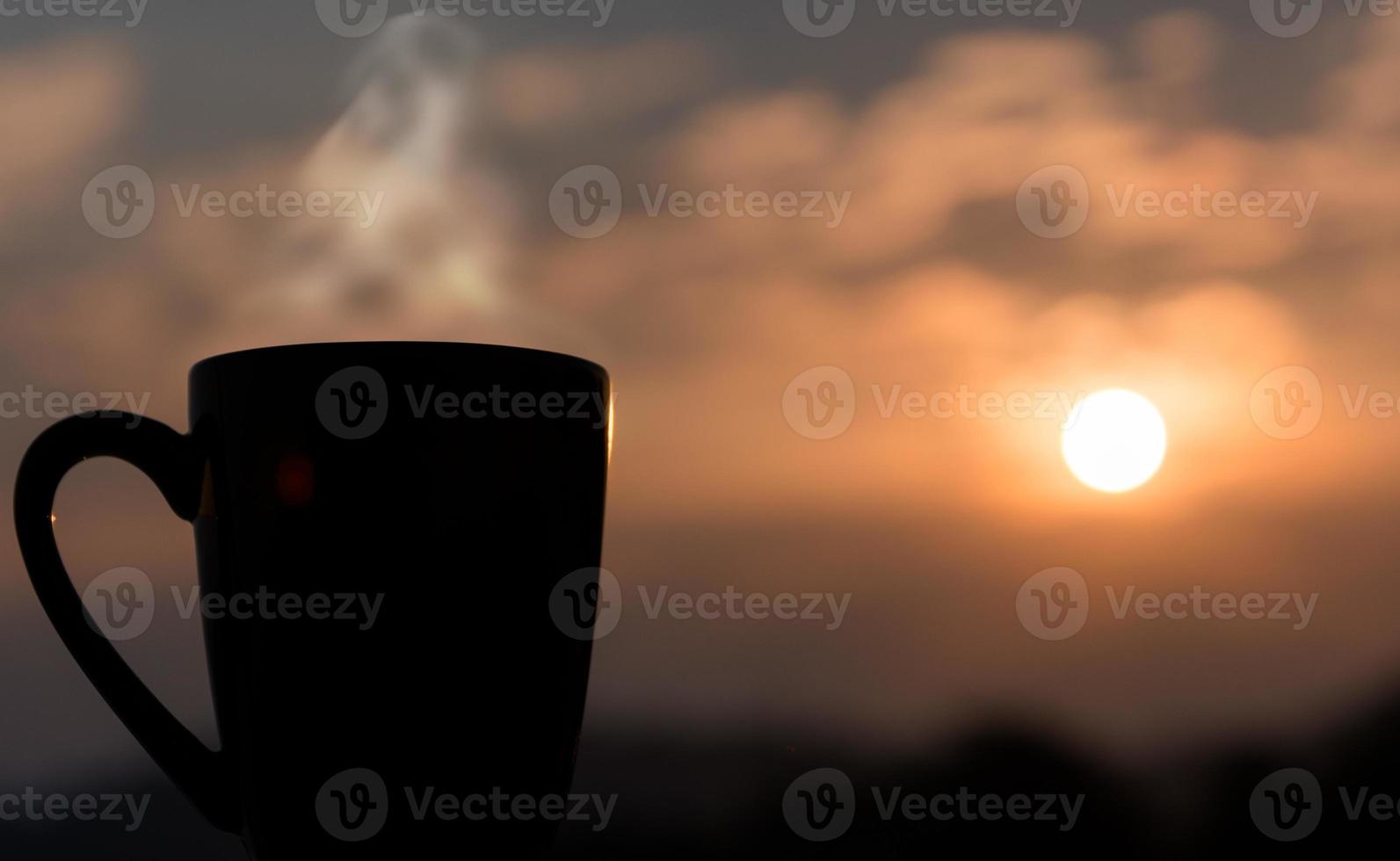 taza de café con puesta de sol de fondo foto