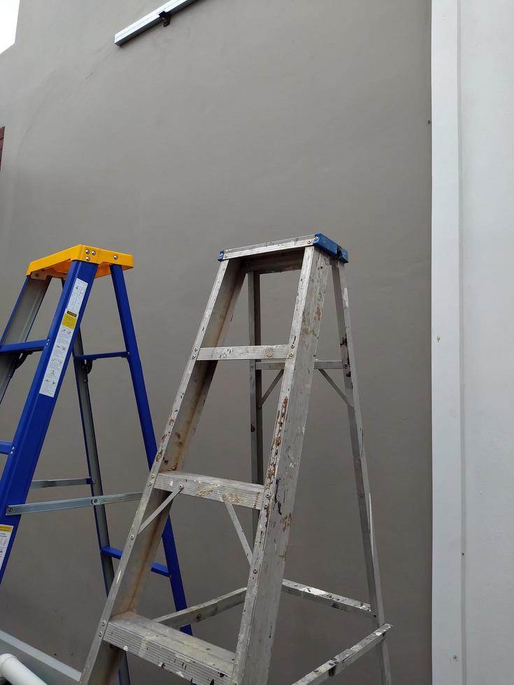 A pair of steel stairs. Steel stairs for construction. A pair of steel stairs stand beside a cement wall. photo