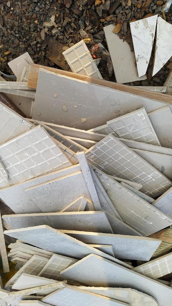 Tile fragments. Tile fragments on the gravel floor. A group of tile fragments in the construction area. photo