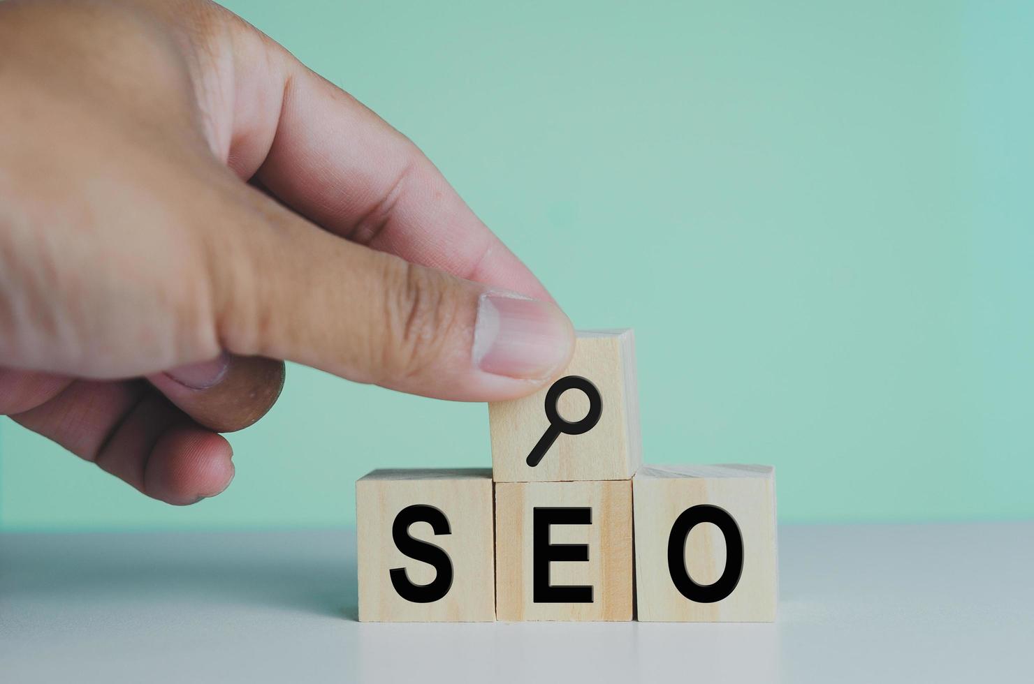 wooden cubes for SEO Search engine optimization magnifying glass icon on background.Copy space. photo