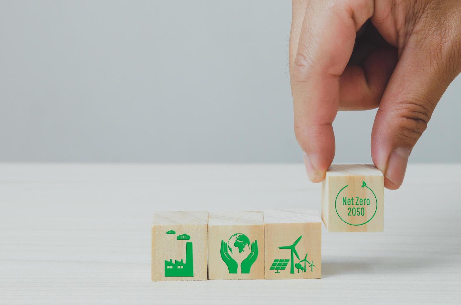 Wooden cubes with net zero and carbon neutral green factory icon symbol background and copy space. photo