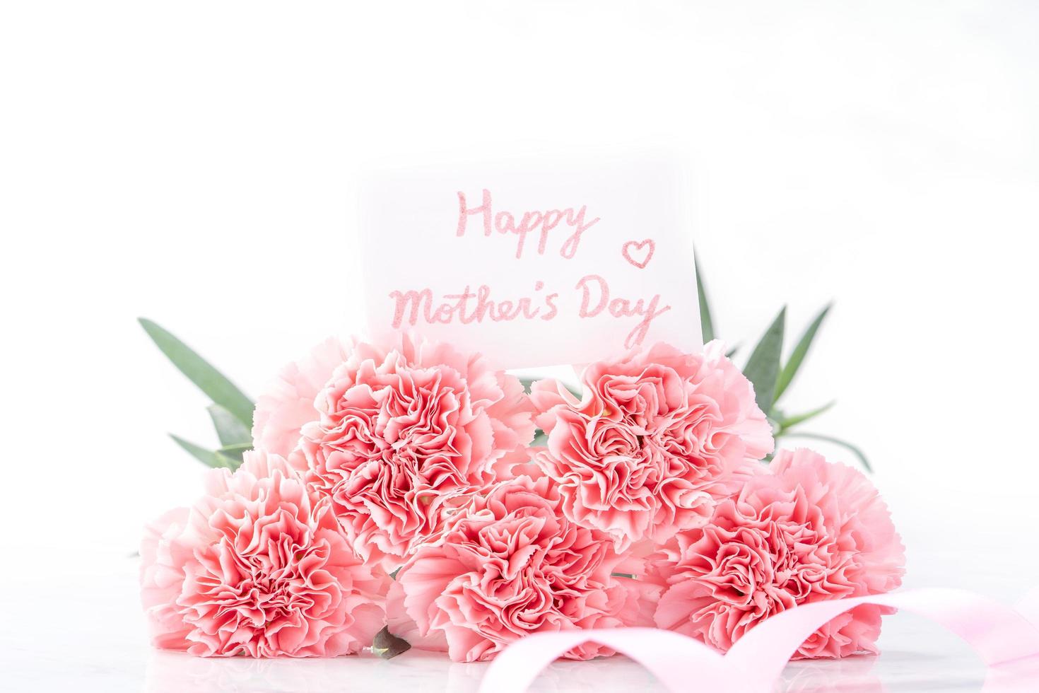 Top view of elegance blooming sweet pink color tender carnations isolated on bright white background with card, may mothers day mum greeting design concept, close up, copy space photo