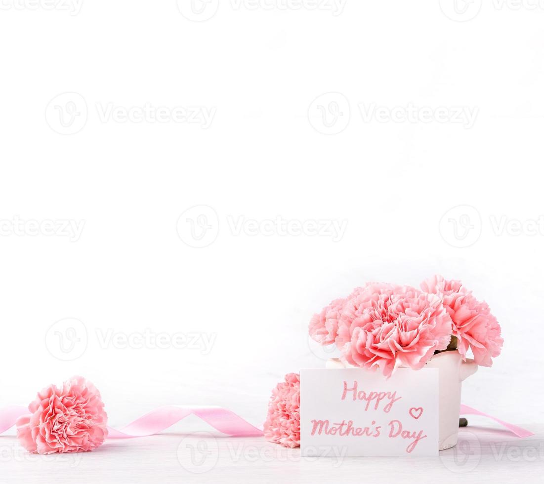 Beautiful blooming baby pink tender carnations in a white vase isolated on bright background, may mothers day greeting mum ideas concept photography, close up, copy space, mock up photo