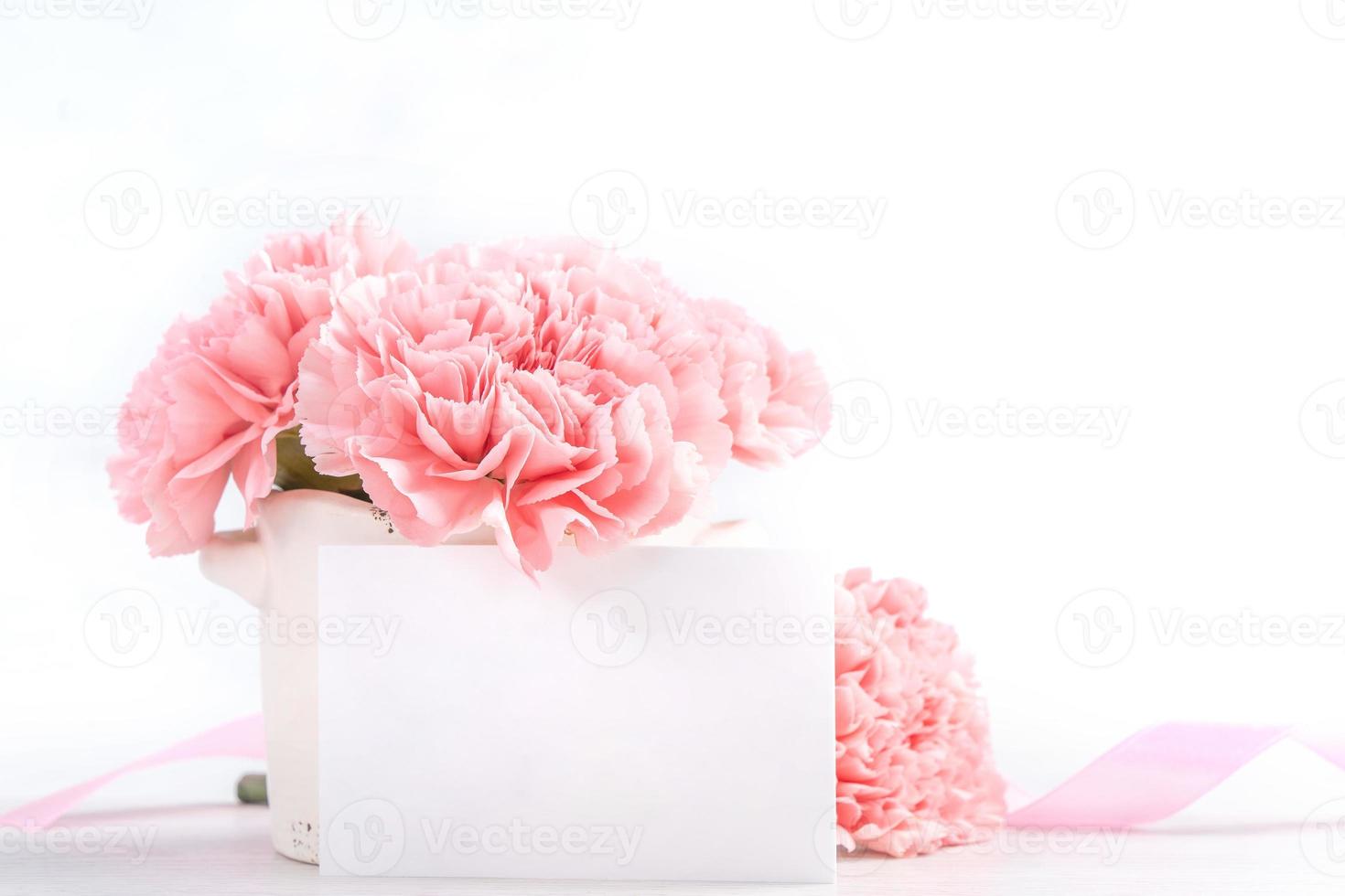 Beautiful blooming baby pink tender carnations in a white vase isolated on bright background, may mothers day greeting mum ideas concept photography, close up, copy space, mock up photo