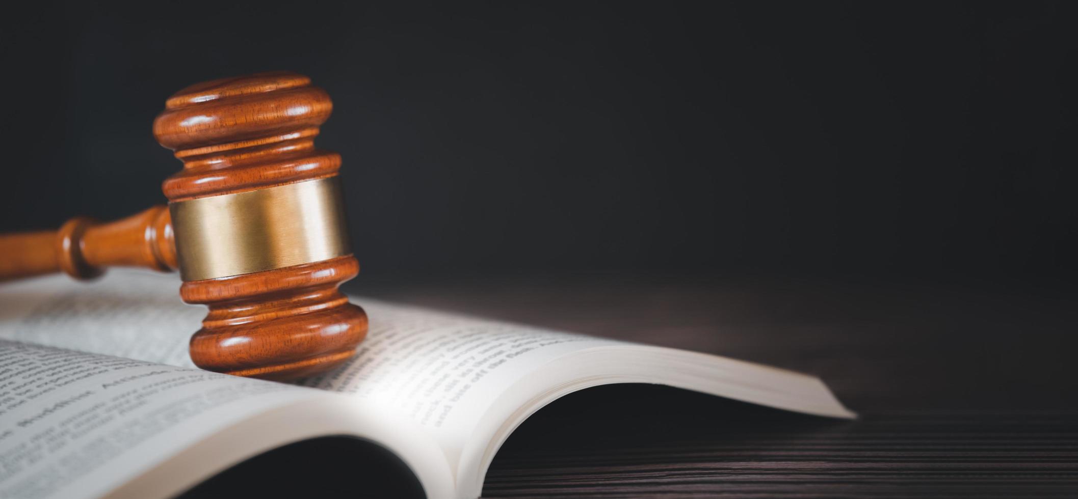 Old wood Judge hammer with law book on the table wood background, Used for adjudication and Justice. photo