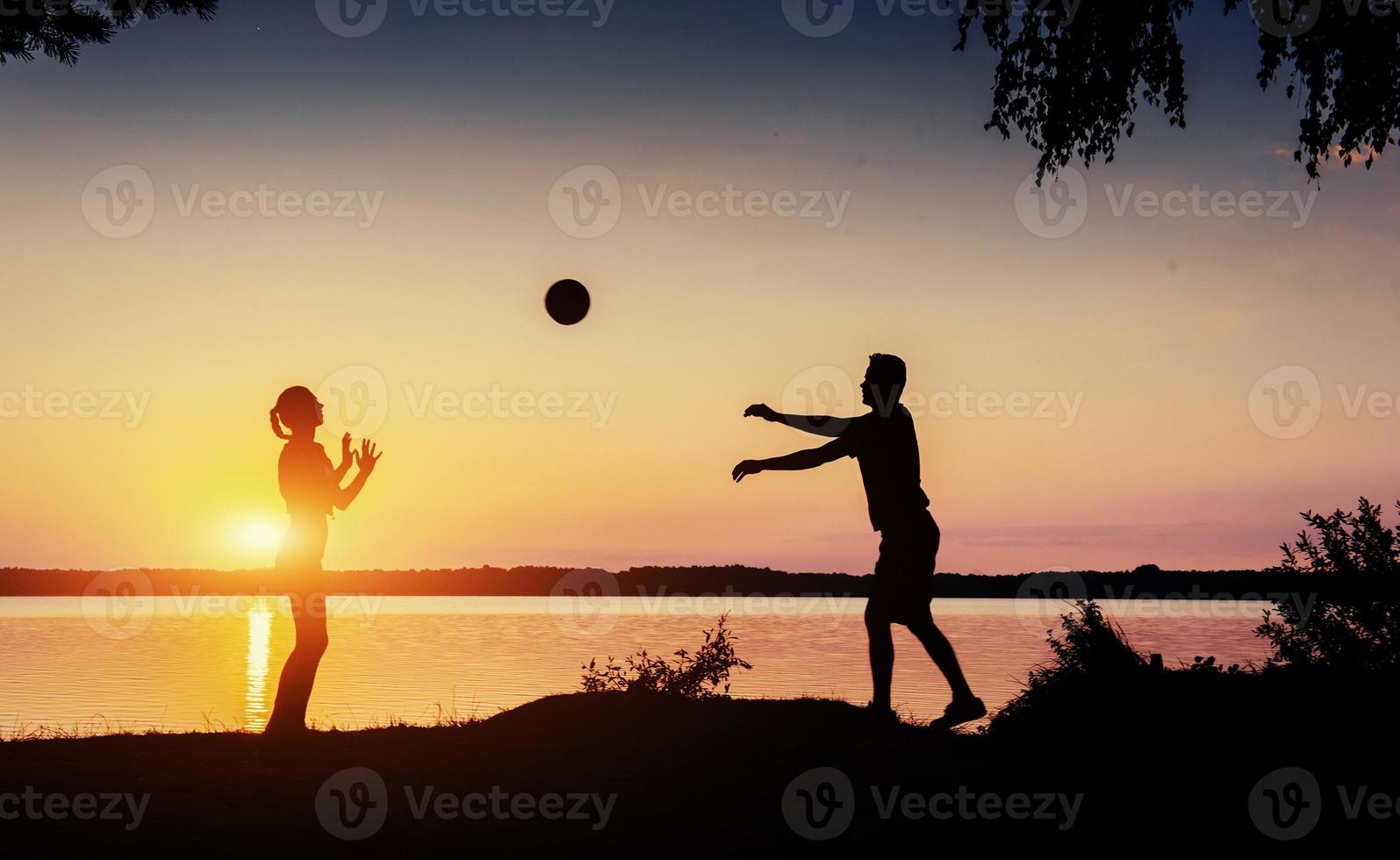 couple in play at sunset by the lake photo