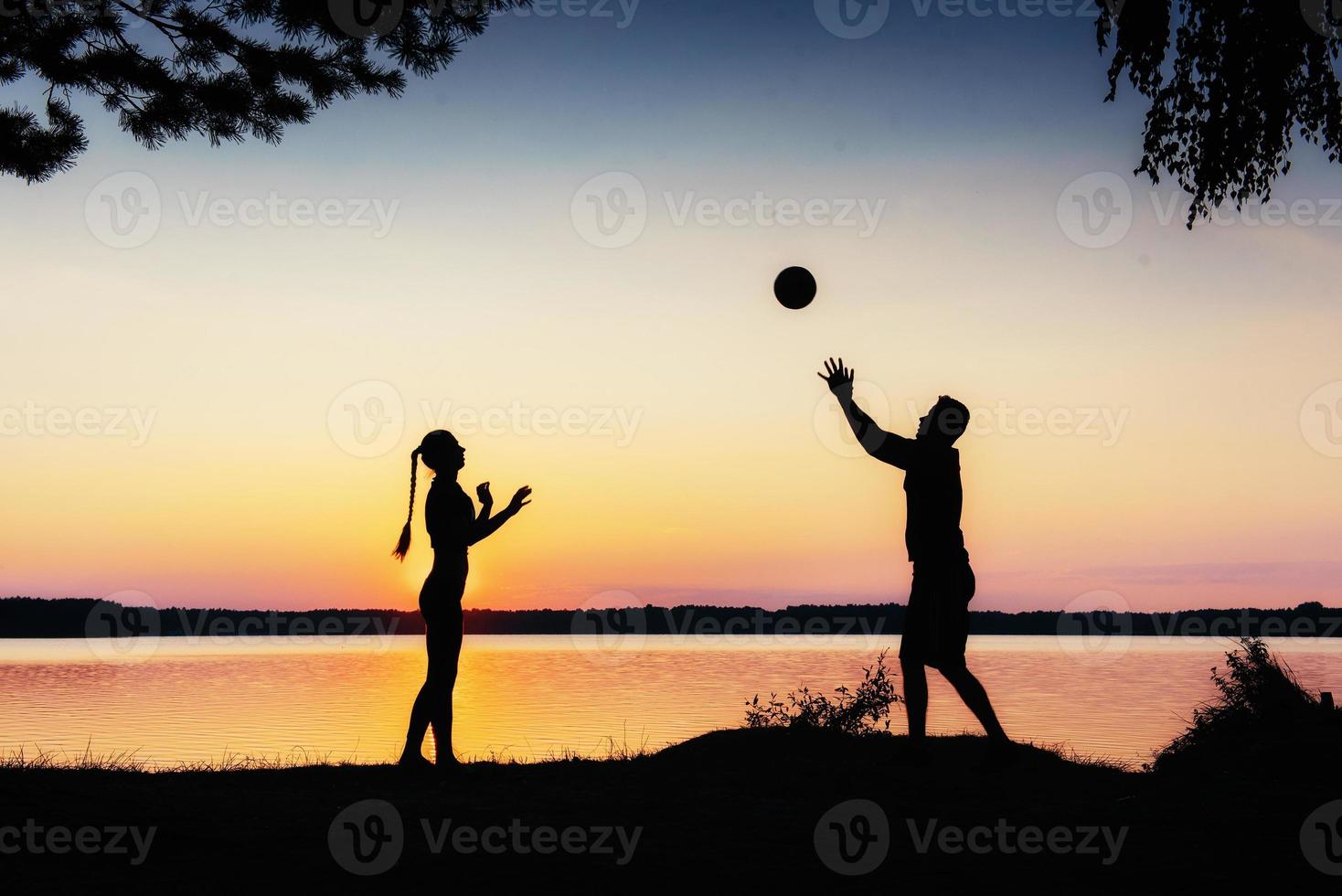 couple in play at sunset by the lake photo