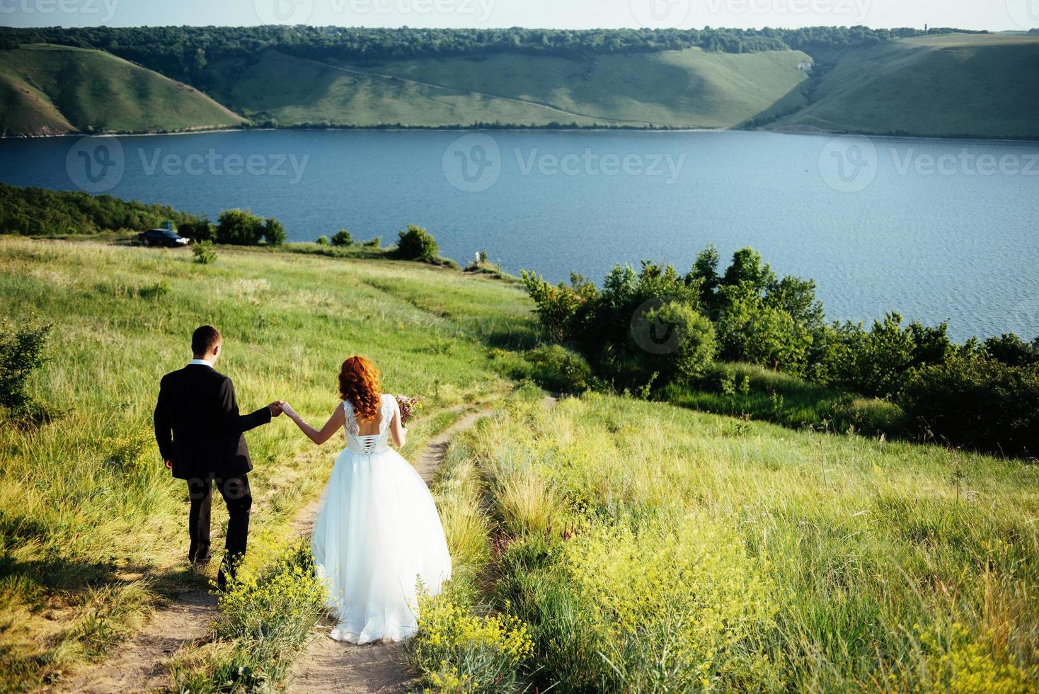 gorgeous blonde bride and groom classy on the rocks, amid the se photo