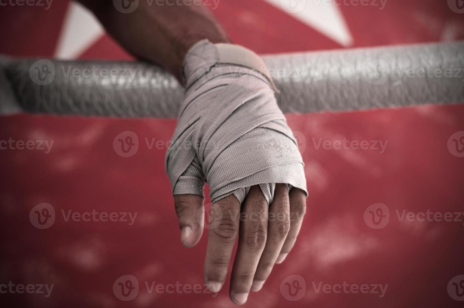 Close up of hand of boxer leaning on ropes on a boxing ring. photo