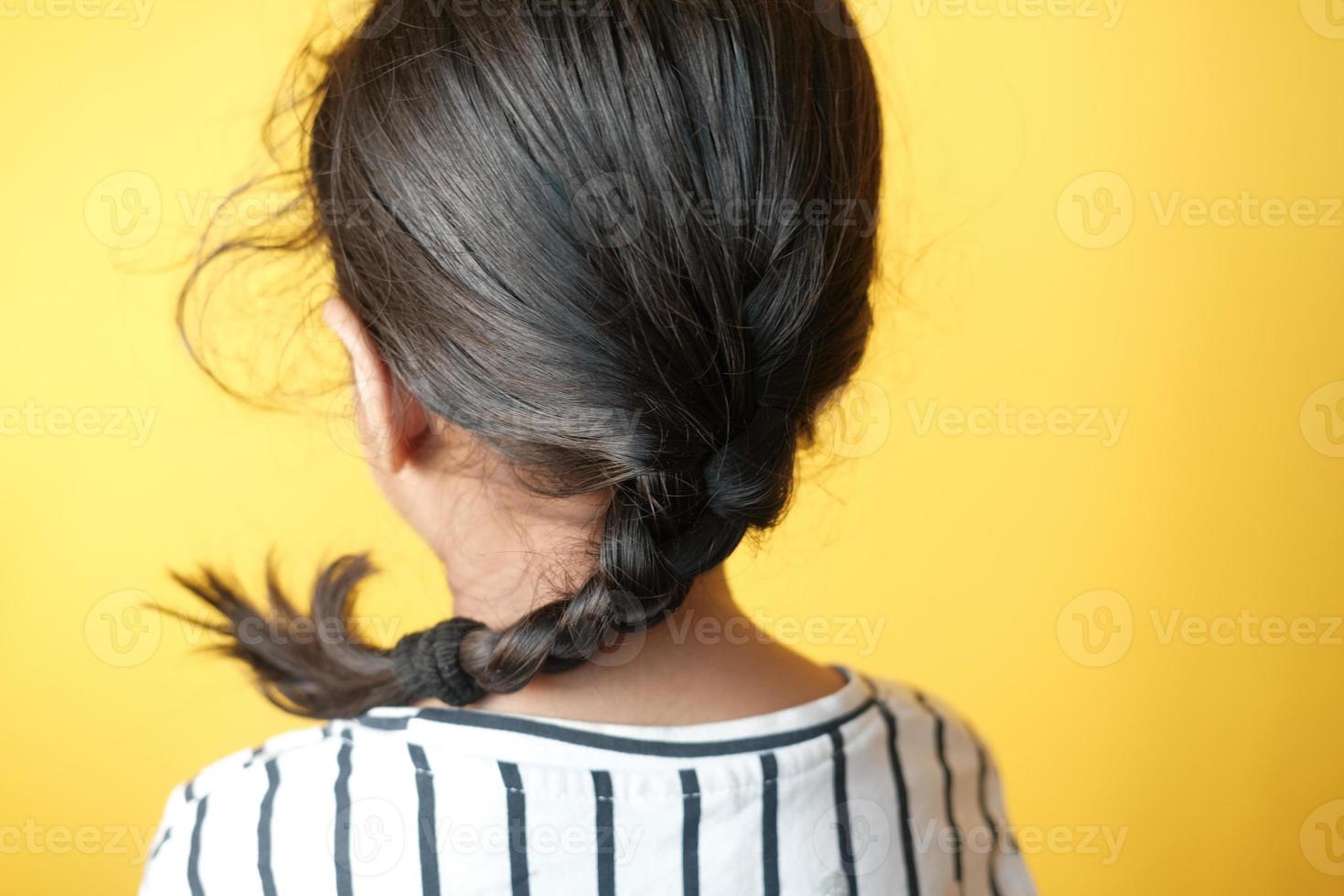 child girl with long hair against yellow background , photo